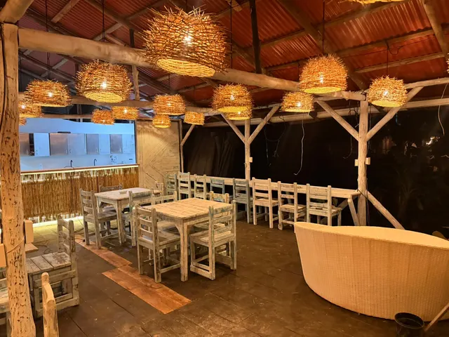 Mesas de madera y sofá de mimbre en el salón del restaurante