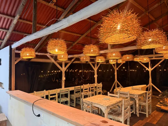 Lámparas tejidas encendidas sobre las mesas del restaurante, vistas desde la barra