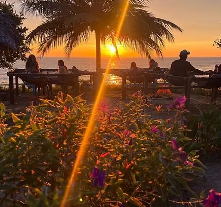 Atardecer desde las zonas comunes de Casa Azul, con mesas frente al mar