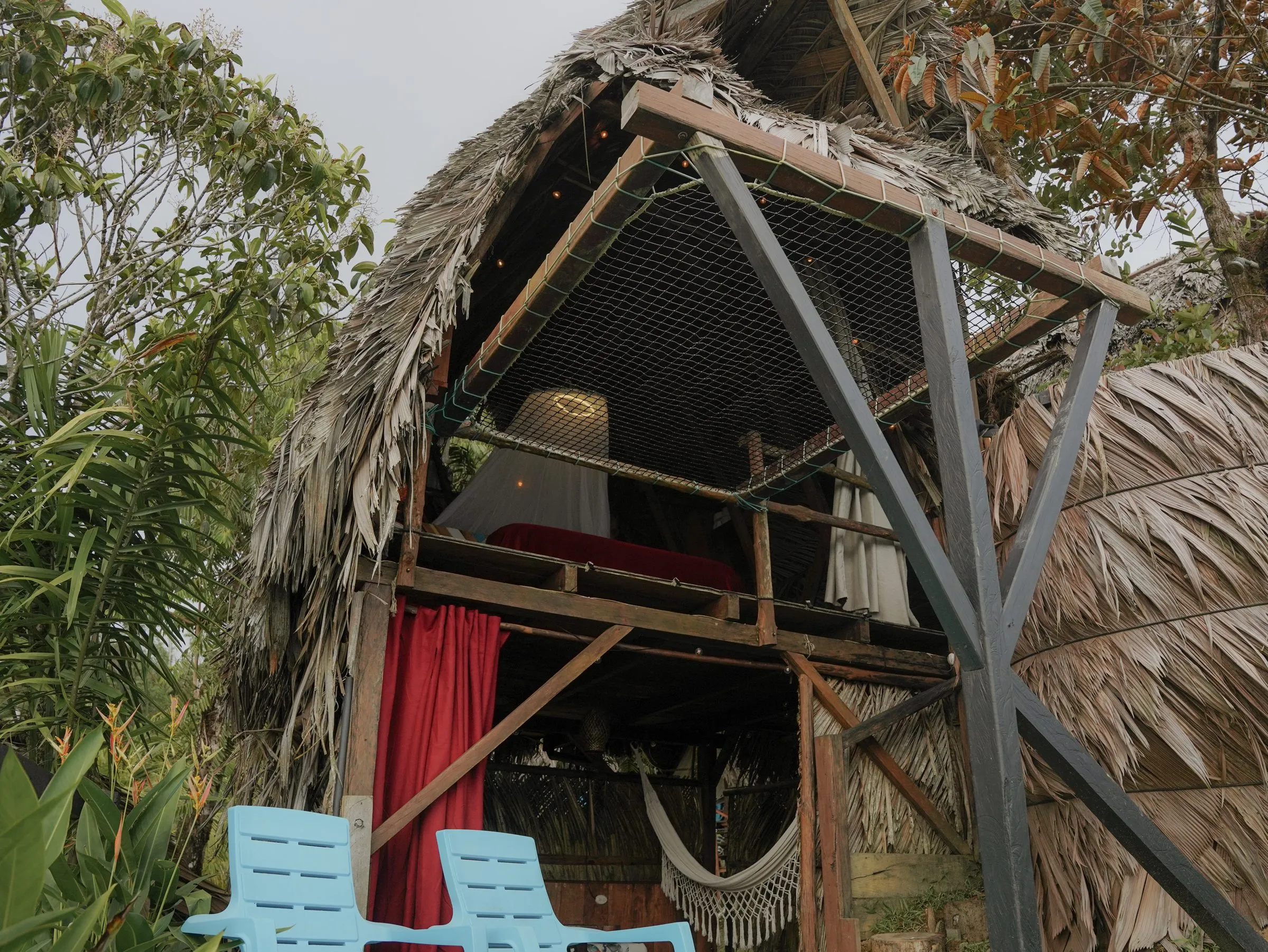 Exterior del Bungalow Maxi 2: estructura abierta de madera y palma entre la vegetacion