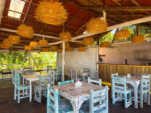 Barra de guadua y mesas del restaurante con la luz del día