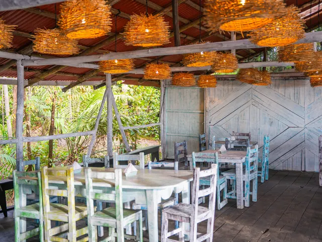 Mesas del restaurante abiertas al jardín y la selva