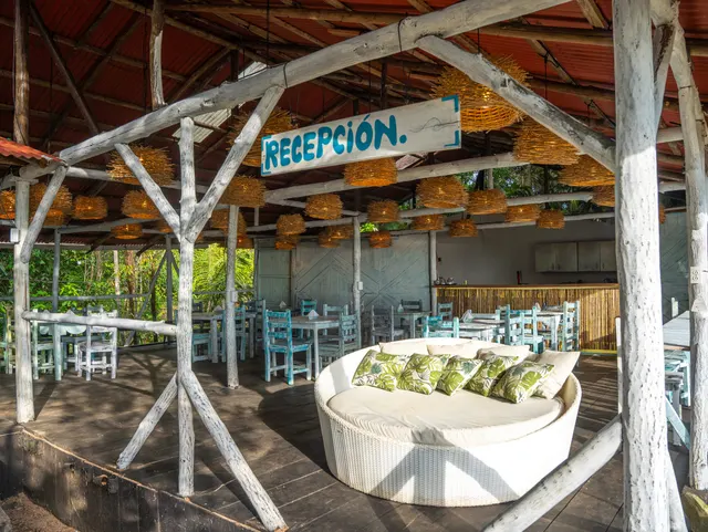 Recepción de Casa Azul dentro del restaurante, con sofá de mimbre