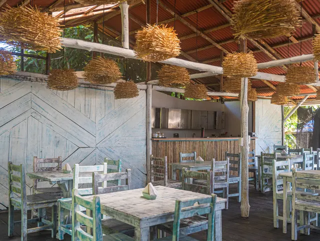 Vista del salón del restaurante con sus mesas y lámparas tejidas