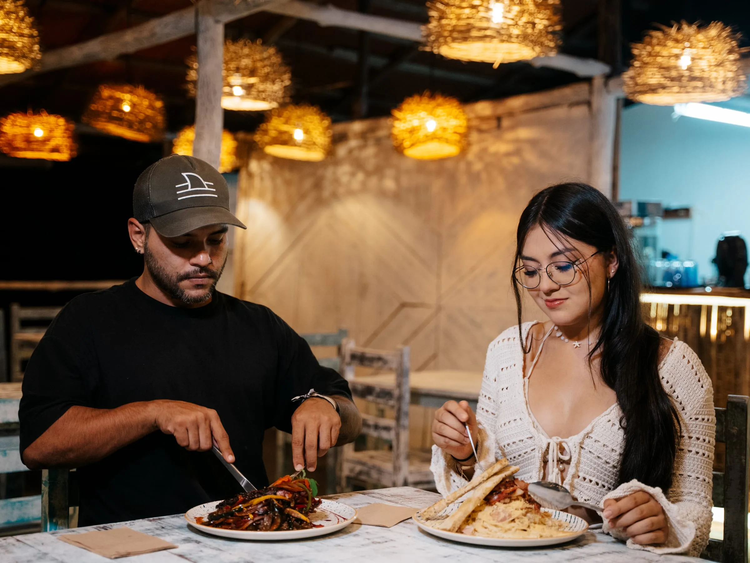 Pareja almorzando en el restaurante de Casa Azul bajo las lámparas tejidas